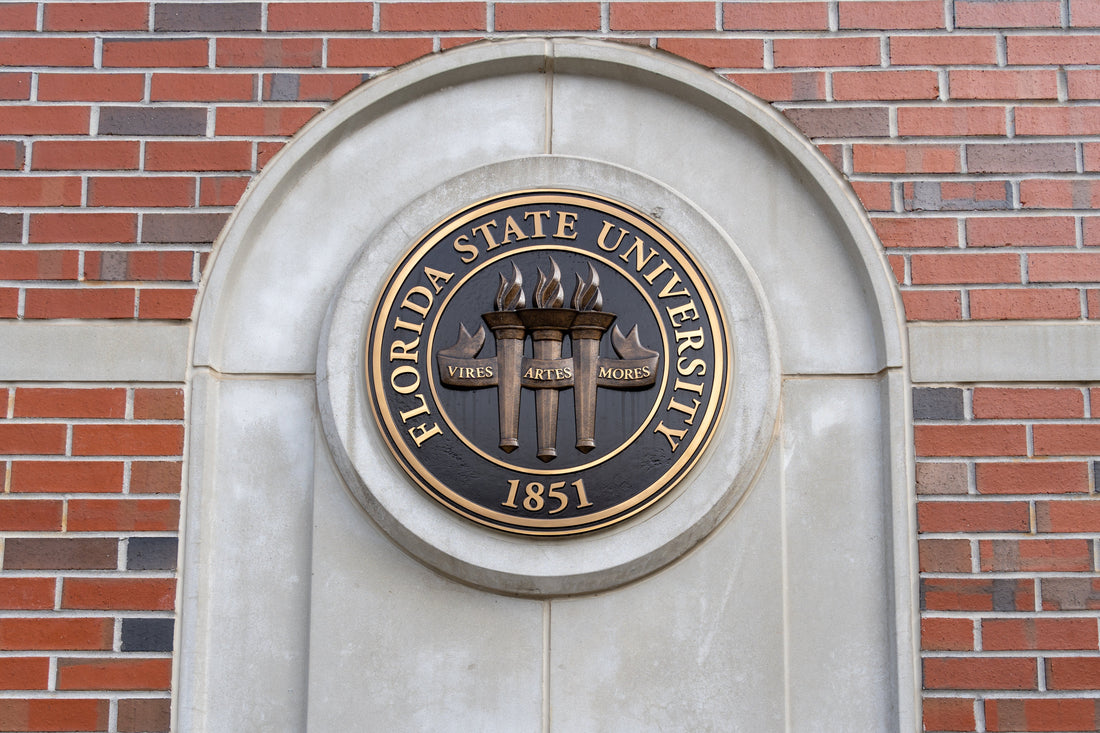 Florida State University emblem on a brick wall, photo creds to JHVEPhoto